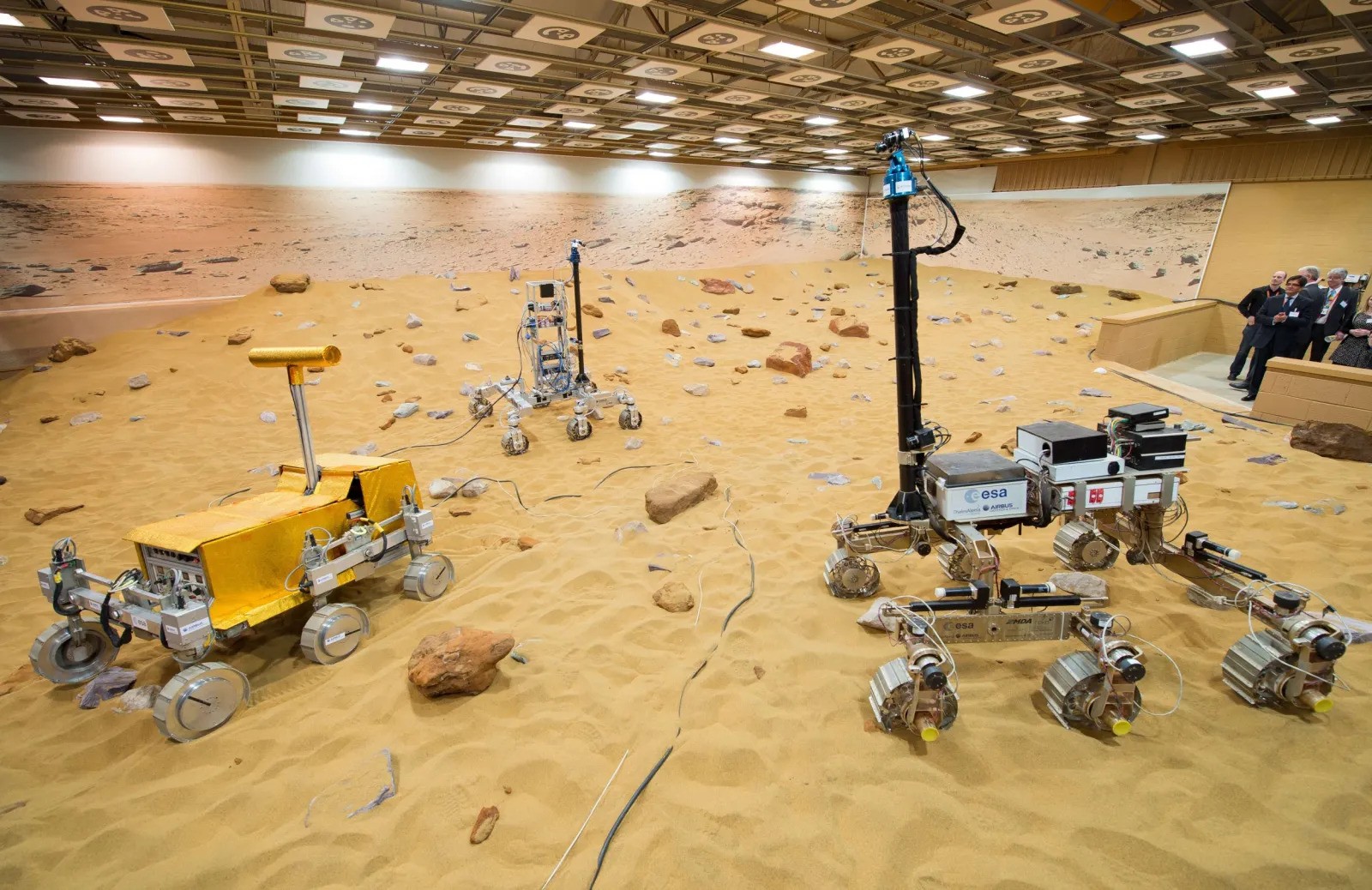 Mars Rover testing environment Internal view of a Mars yard testing environment featuring robotic rover prototypes on simulated planetary terrain within a controlled research and development facility.