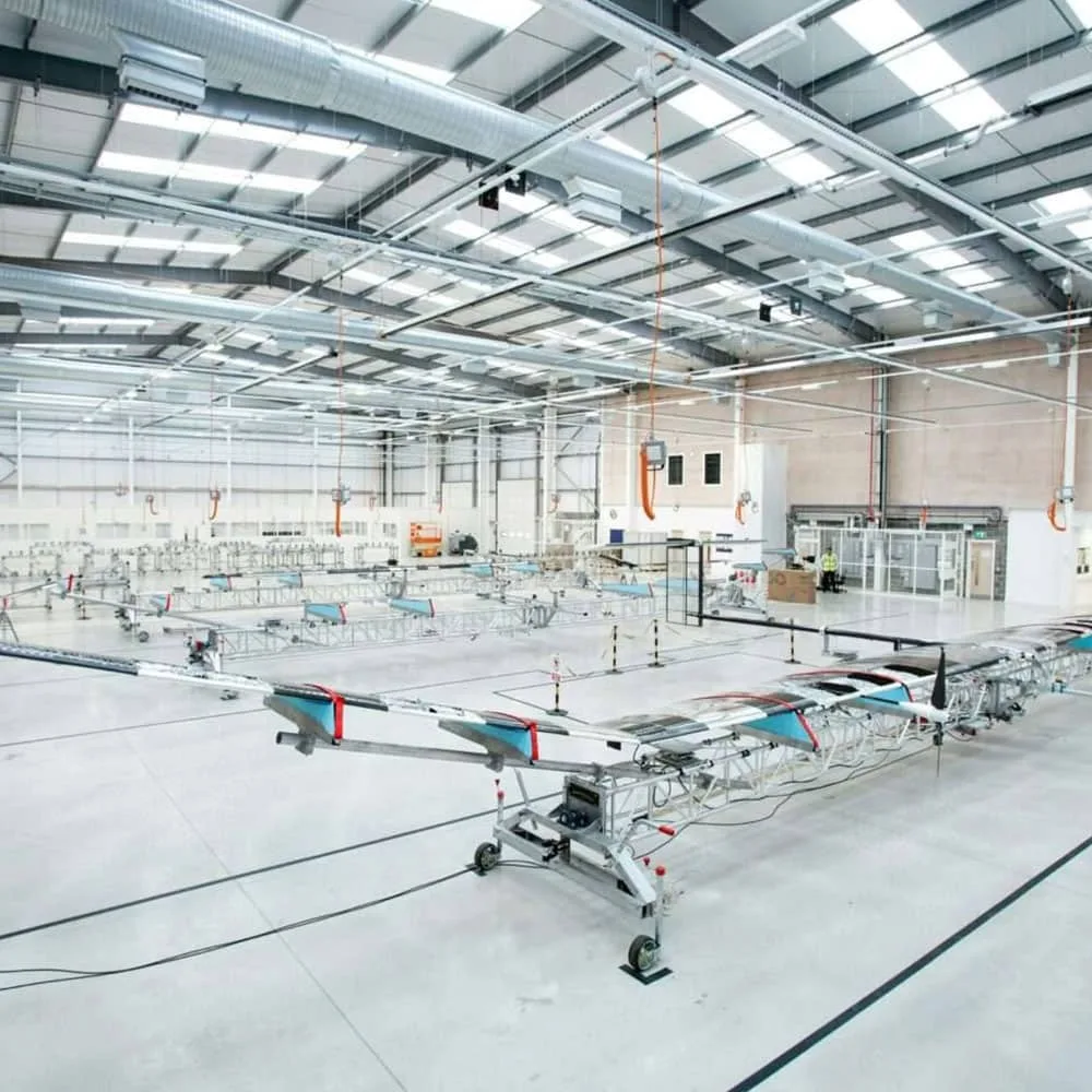 High-tech aerospace manufacturing and testing facility interior showing aircraft structures and specialist equipment within a large industrial workspace, Farnborough Hampshire