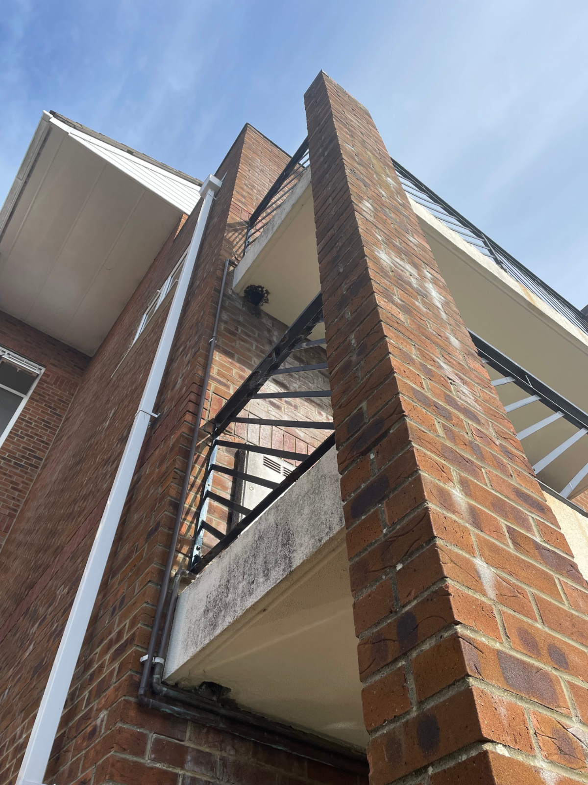 Scaffolded residential block undergoing external maintenance Scaffolded residential block undergoing external maintenance and building repair works, showing access platform and façade improvement works in progress, Poole Dorset