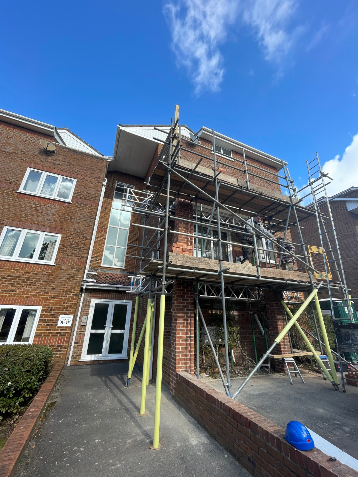 Scaffolded residential block undergoing external maintenance Scaffolded residential block undergoing external maintenance and building repair works, showing access platform and façade improvement works in progress, Poole Dorset