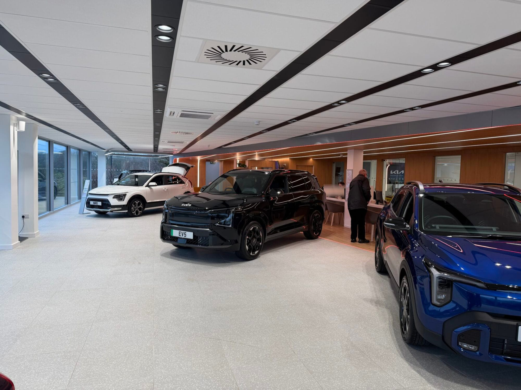 Internal showroom photograph showing 3 KIA cars and new showroom building recently completed in Plymouth Devon