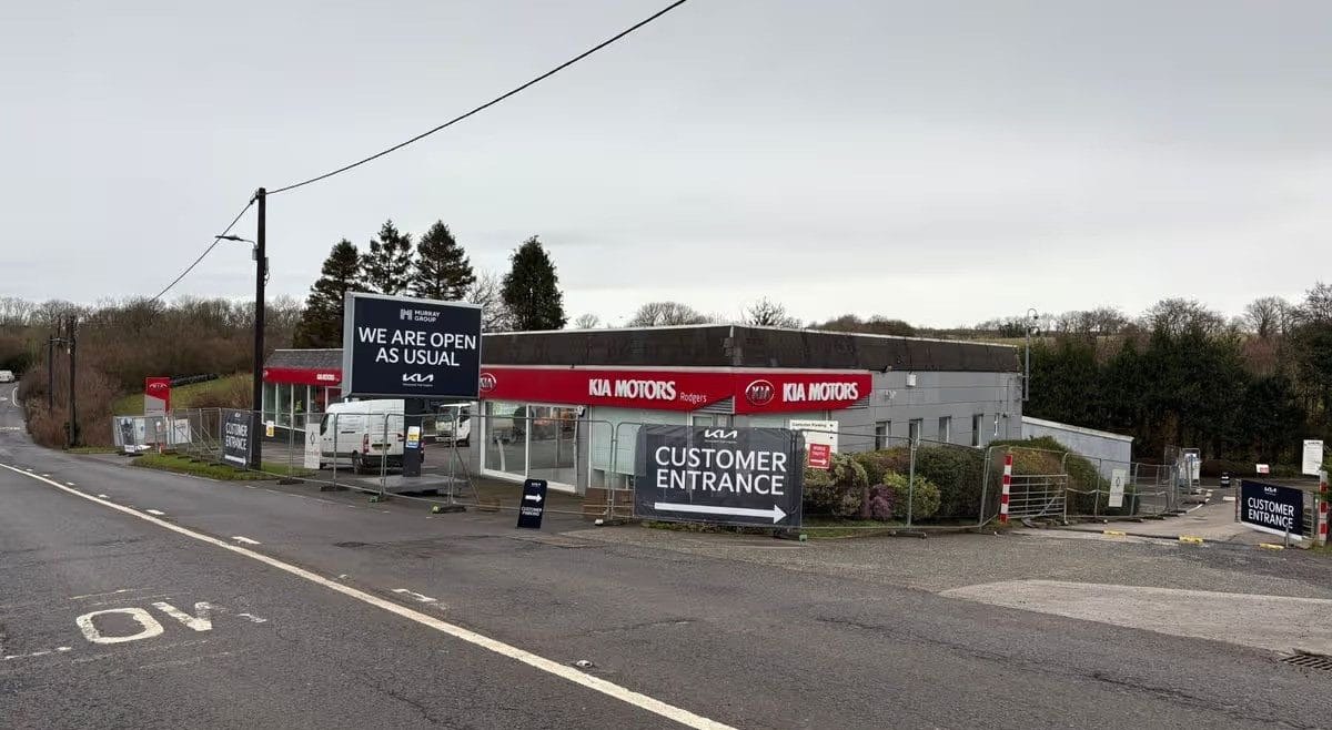 Drone aerial photograph of previous Kia Plymouth dealership showcasing an old style car showroom and forecourt with heras fencing
