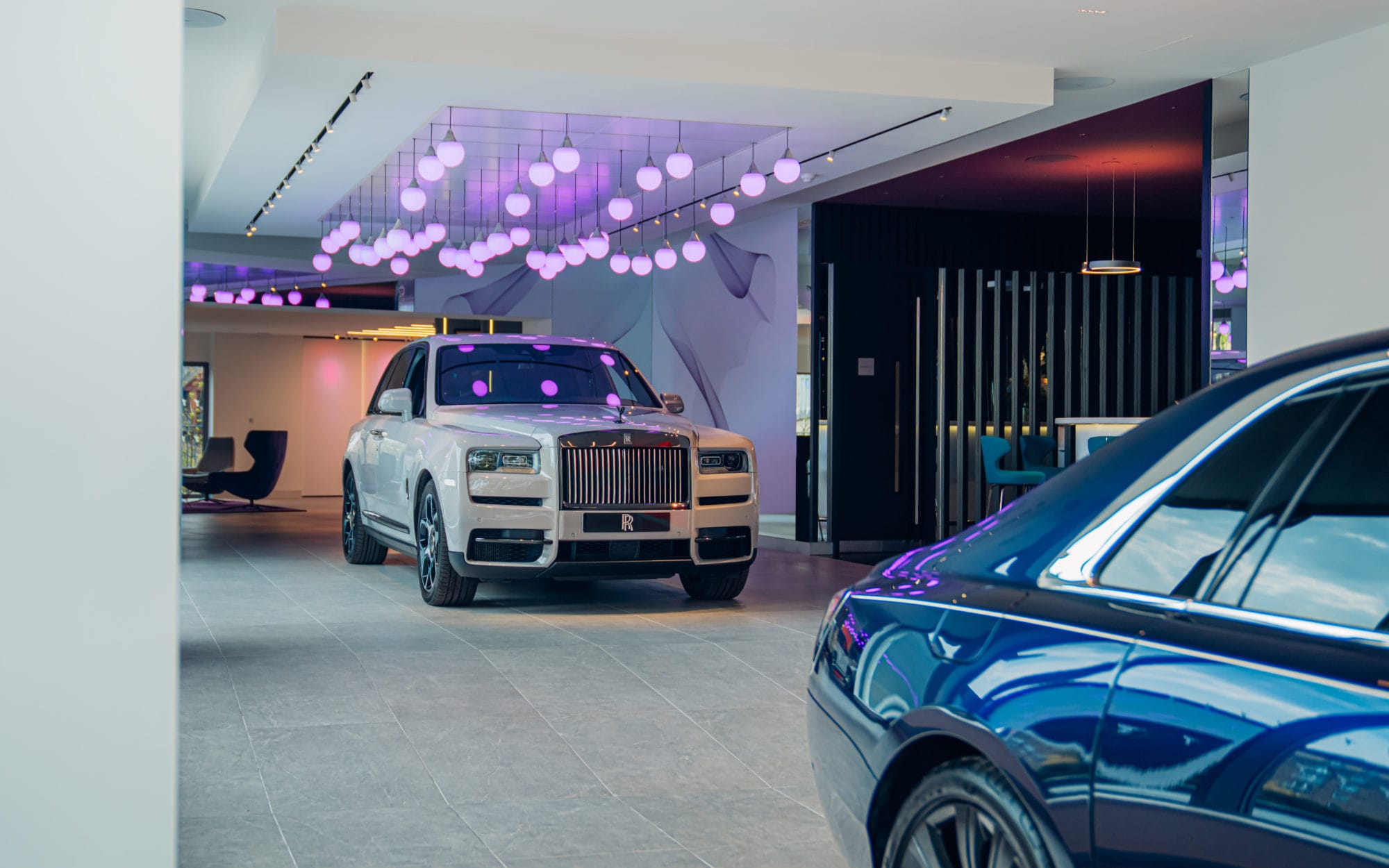 Luxury Rolls-Royce car displayed inside a modern dealership showroom Luxury Rolls-Royce car displayed inside a modern dealership showroom interior with premium retail fit-out and display area