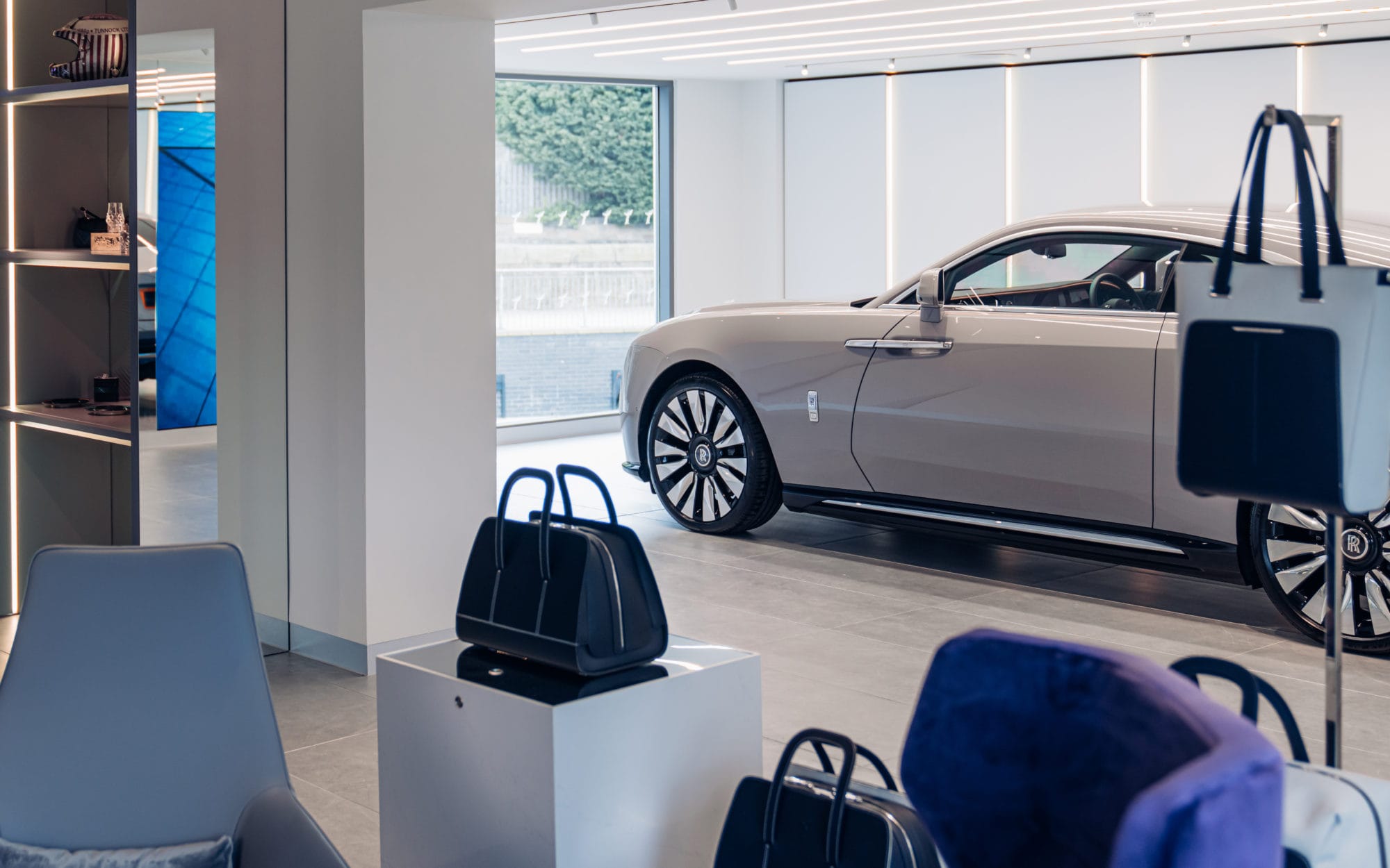 Luxury Rolls-Royce car displayed inside a modern dealership showroom Luxury Rolls-Royce car displayed inside a modern dealership showroom interior with premium retail fit-out and display area
