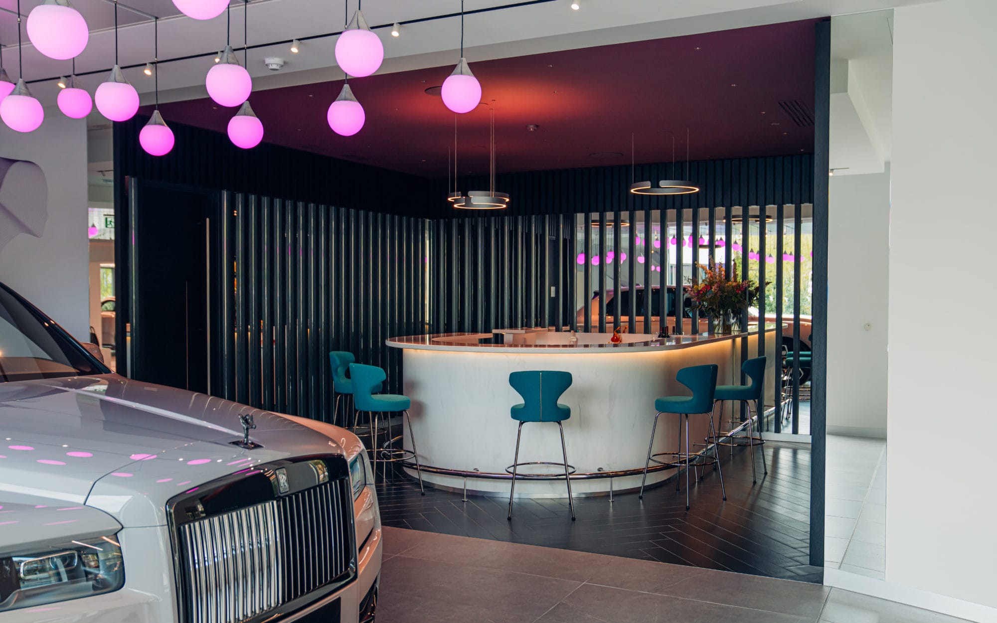 Luxury Rolls-Royce car displayed inside a modern dealership showroom Luxury Rolls-Royce car displayed inside a modern dealership showroom interior with premium retail fit-out and display area